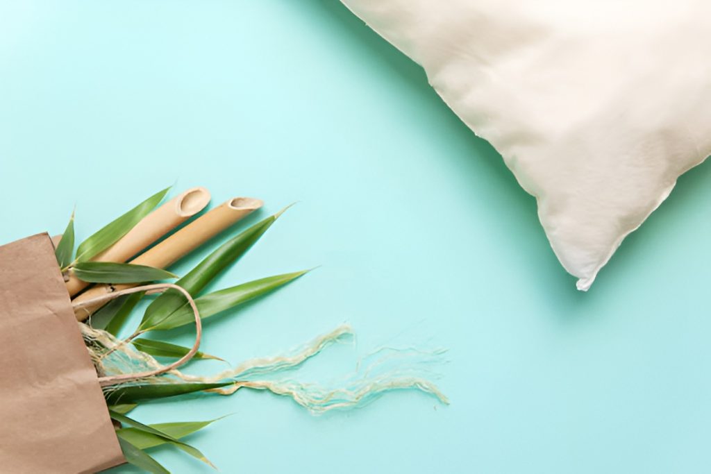 bamboo pillow next to a paper bag filled with bamboo leaves