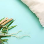 bamboo pillow next to a paper bag filled with bamboo leaves